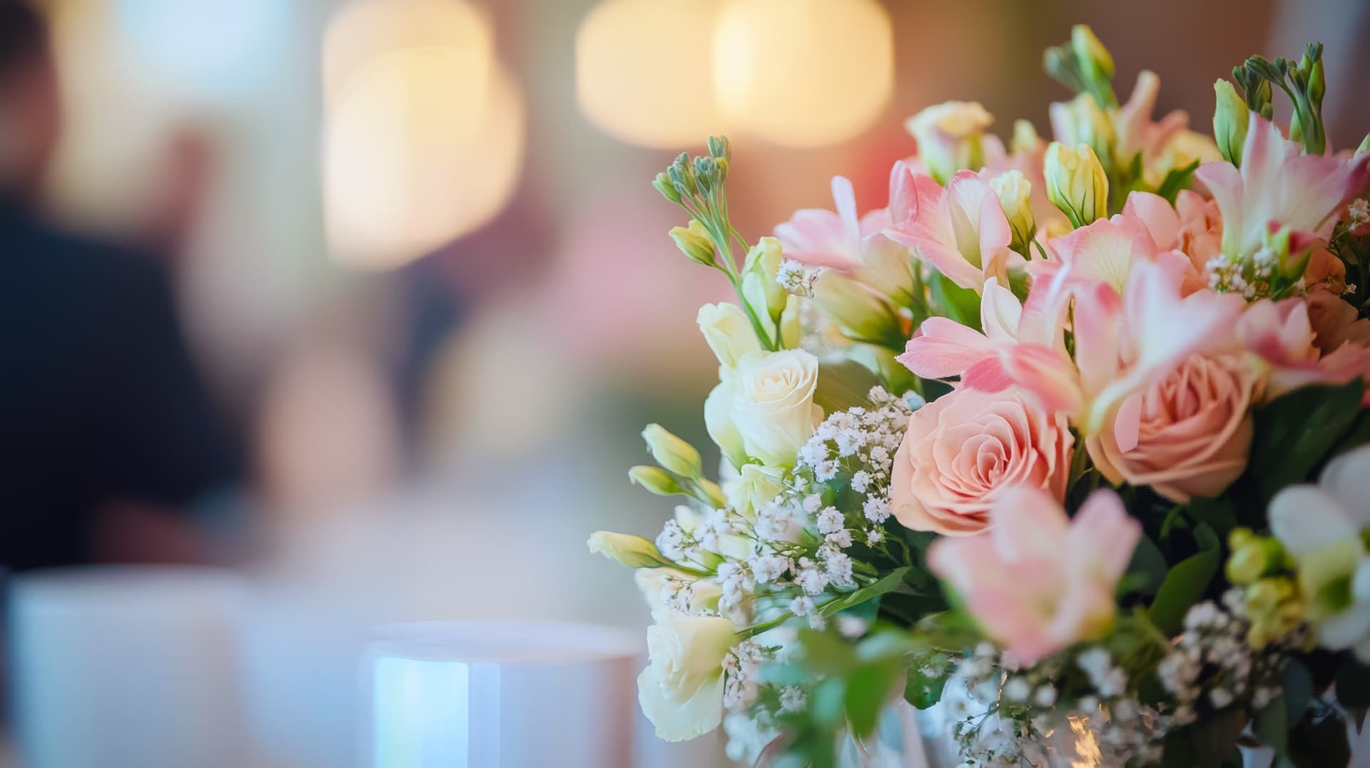 Pink roses, lilies and baby's breath in an elegant event arrangement